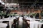 Interior del salón de eventos decorado para boda con mesas blancas y arreglos florales