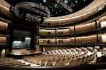 Interior del CMA Theater con butacas blancas y escenario iluminado