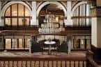 Área de lounge en el interior del hotel con arcos y lámpara colgante