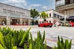 Plaza exterior del centro comercial con arquitectura moderna y vegetación