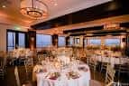 Salón interior decorado para boda con mesas redondas y iluminación elegante