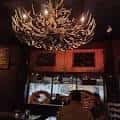 Interior del bar con lámpara de cuernos y ambiente acogedor
