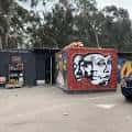 Fachada exterior del Che Café Collective con arte mural colorido