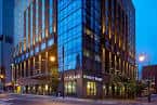 Ángulo lateral del edificio con iluminación urbana y detalles arquitectónicos modernos