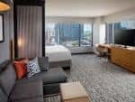 Suite ejecutiva interior con vista a la ciudad y zona de estar moderna
