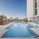 Piscina al aire libre del hotel Margaritaville con tumbonas y vista a la ciudad
