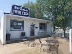 Vista exterior del local Rosie's Twin Kegs con su letrero distintivo y mesas al aire libre