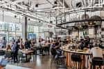 Vista general del interior de Little Italy Food Hall con mesas y comensales