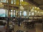Salón interior con espejos, arañas y mesas dispuestas para recepción o cena