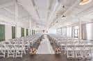 Salón principal decorado para ceremonia con pasillo central blanco