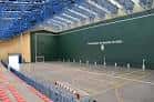 Interior del pabellón con pista deportiva y gradas vacías