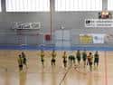 Interior del polideportivo mostrando cancha deportiva con jugadores en formación