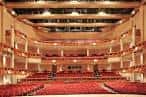 Interior del auditorio principal con butacas rojas y balcones ornamentados