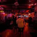 Interior del bar con iluminación roja y ambiente de fiesta