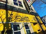 Fachada exterior amarilla del Starday Tavern con su letrero distintivo
