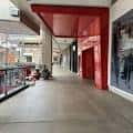 Pasillo interior del centro comercial con columnas y detalles arquitectónicos modernos