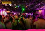 Interior del bar The Tipsy Crow con ambiente festivo y luces de discoteca