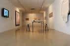 Interior de la galería principal con obras expuestas y mobiliario minimalista