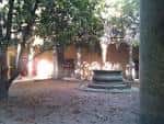 Jardín central del convento con fuente y árboles, espacio acogedor para recepciones
