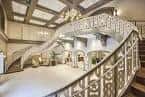 Escalera principal curva con barandilla ornamentada en el lobby