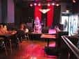 Interior del Skylark Café & Club con escenario iluminado en rojo y público sentado