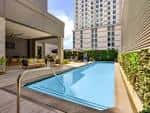 Piscina exterior con zona de descanso y vista al edificio del hotel