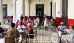 Interior del comedor con personas sentadas en mesas bajo arcos coloniales
