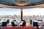 Vista panorámica del interior de Mister A's con mesas dispuestas y vistas a la ciudad