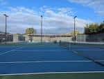 Pistas de tenis al aire libre con superficie azul y redes instaladas