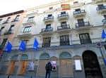 Vista exterior del Teatro de la Comedia con fachada neoclásica y banderas azules