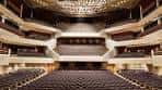 Interior del auditorio vacío, mostrando butacas rojas y diseño acústico en forma de concha