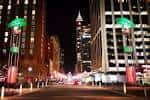 Vista nocturna de City Plaza en Raleigh con edificios iluminados y ambiente festivo