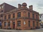 Fachada exterior del pub Tiny Rebel en Cardiff, edificio de ladrillo rojo con detalles arquitectónicos victorianos