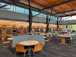 Interior de la biblioteca remodelada con mesas y estanterías