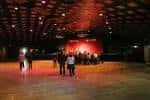 Escenario con iluminación roja y personas en el salón principal