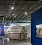 Interior de la galería con una instalación artística y paredes azules