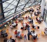 Interior del centro de eventos con personas reunidas en mesas