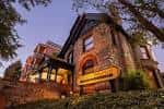 Fachada exterior del Molly Brown House Museum al atardecer con letrero iluminado