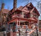 Vista frontal de la casa histórica en estilo victoriano con detalles arquitectónicos y escalinata