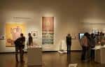 Interior de la galería principal con obras expuestas y visitantes