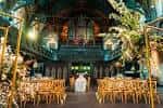 Ceremonia de boda en el interior del salón principal con decoración floral y órgano al fondo