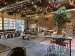 Interior del espacio de eventos con mesas y sillas dispuestas para una reunión