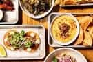Mesa con variedad de platos asiáticos fusionados y aperitivos del restaurante