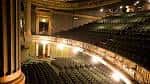 Interior del teatro con butacas vacías y decoración clásica iluminada