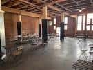 Interior del salón de eventos con mesas y sillas dispuestas para una celebración