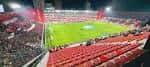 Vista panorámica nocturna del estadio con gradas llenas y campo iluminado