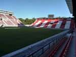 Interior del estadio mostrando las tribunas rojas y blancas bajo el sol