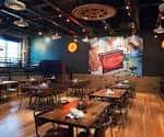 Interior del Char Bar con mesas y decoración industrial