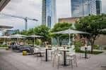 Terraza exterior del Artisan Craft Kitchen & Terrace Bar con mesas y sombrillas en Dallas