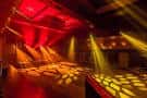Sala de baile o evento con iluminación dinámica roja y amarilla
